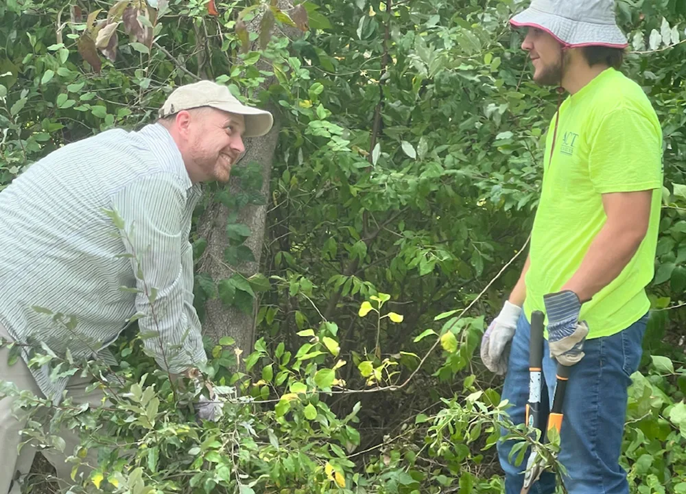workers clearing over growth on trails